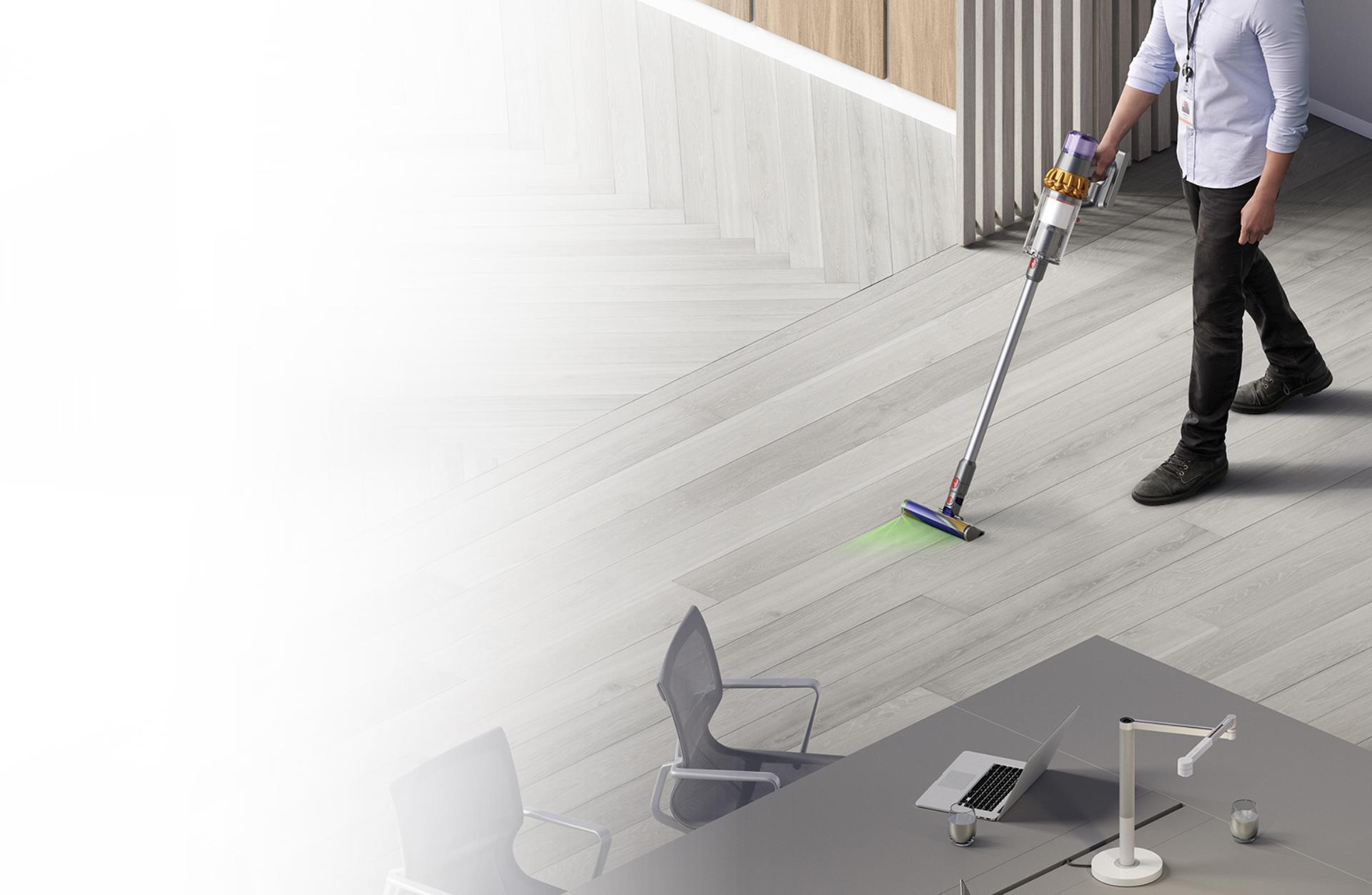 Man cleaning floor with Dyson V15 Detect vacuum
