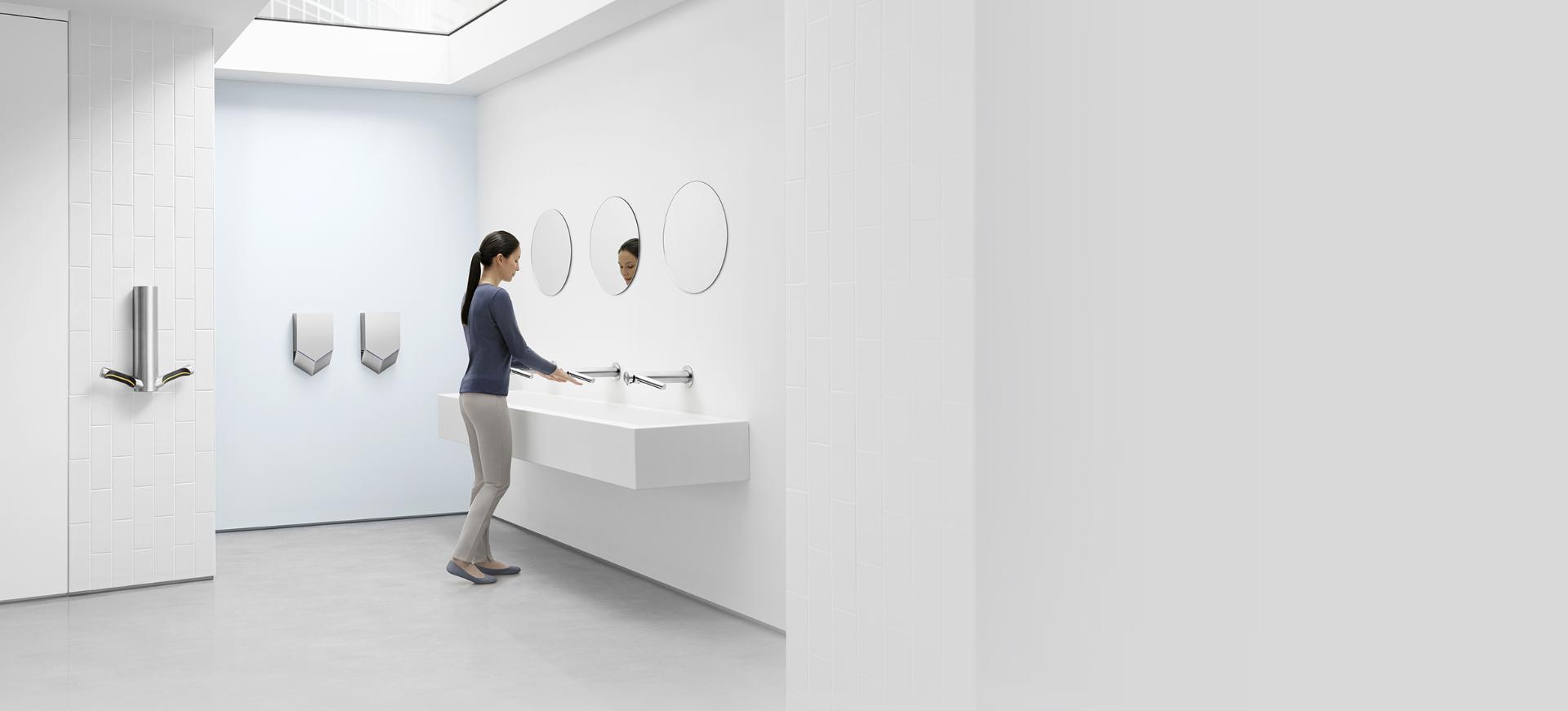 Woman drying hands with Dyson Airblade Wash+Dry hand dryer