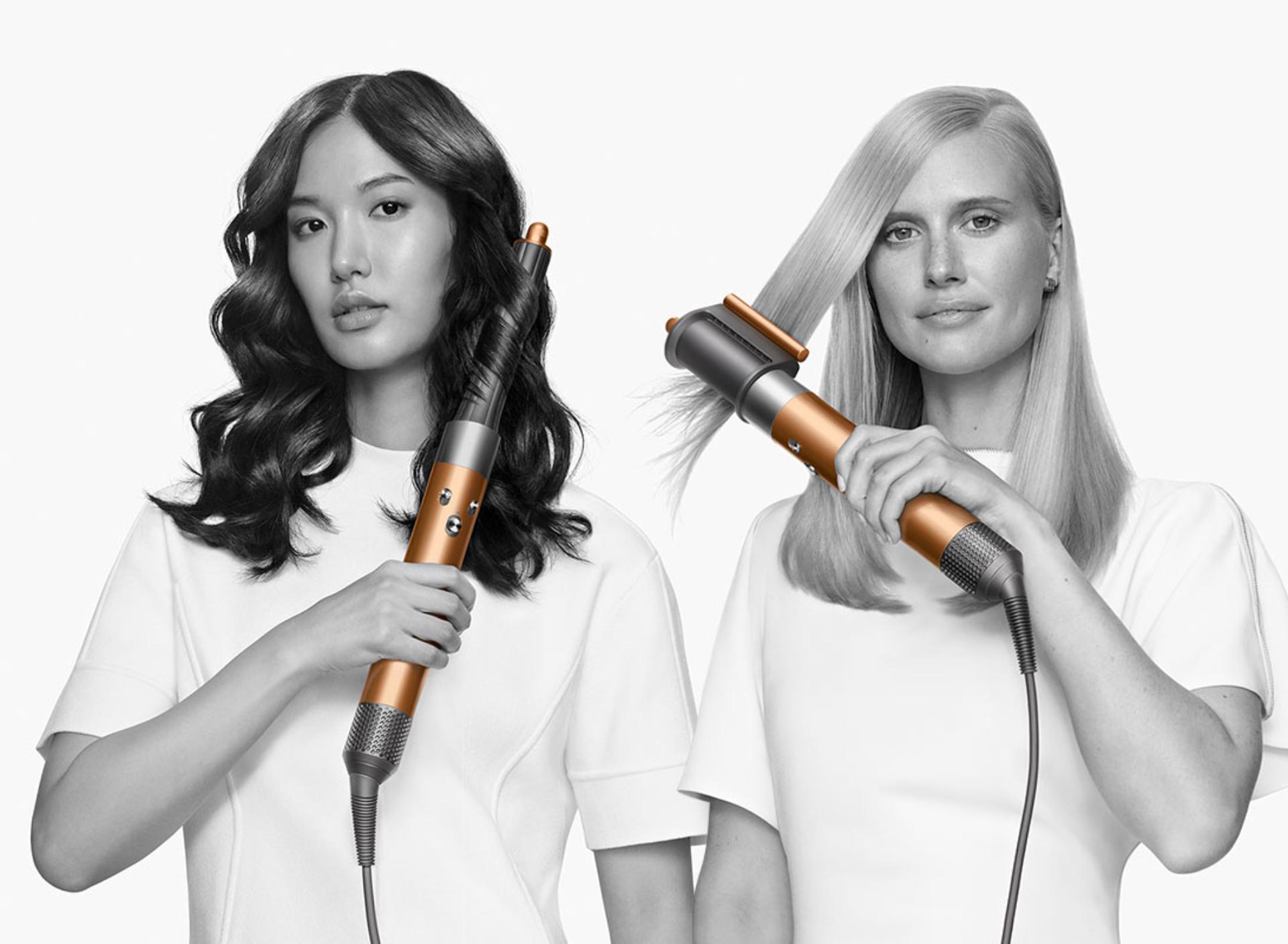 Two models using the Dyson Airwrap styler to curl hair 