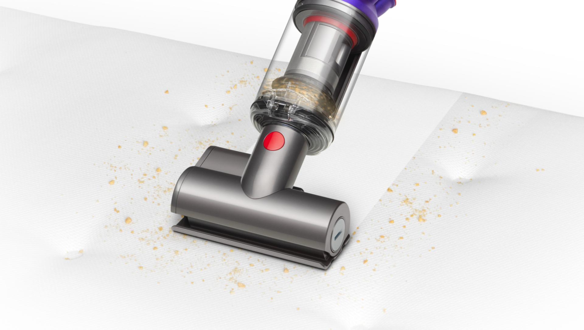 Mini motorised tool being used to clean a mattress.