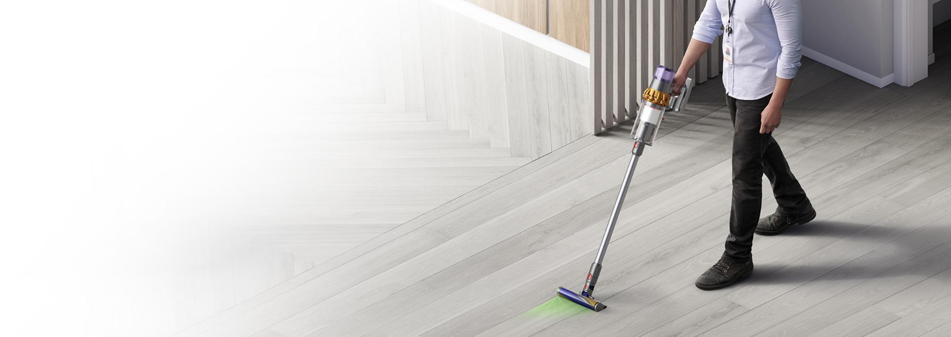Man cleaning work space with Dyson cordless vacuum
