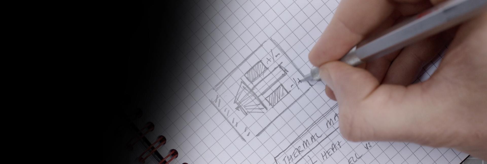 Close-up of James Dyson sketching on paper