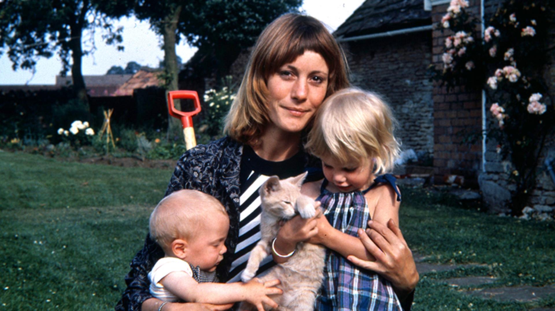 Deirdre Dyson holding toddler Emily, a young baby Jake, and a pet cat