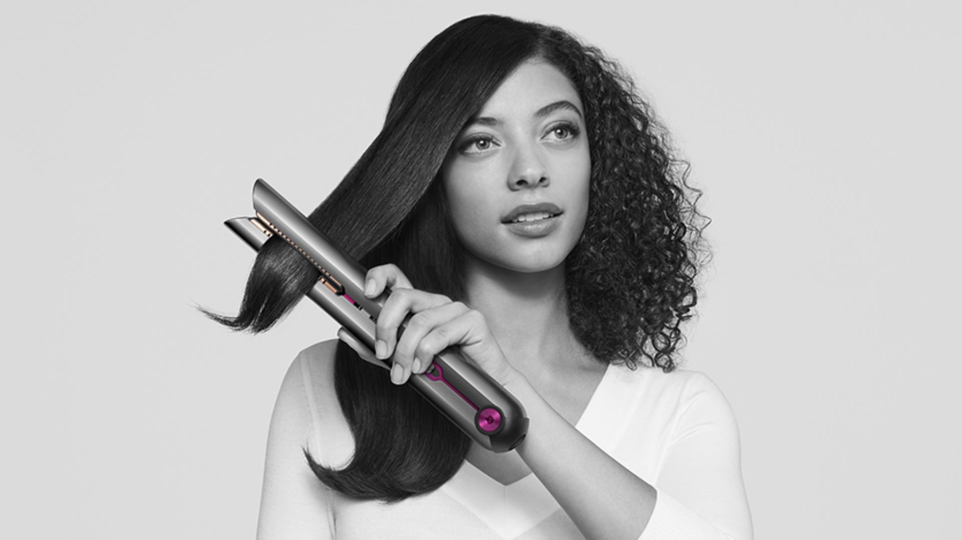 Female model holding the Dyson Corrale straightener in one hand