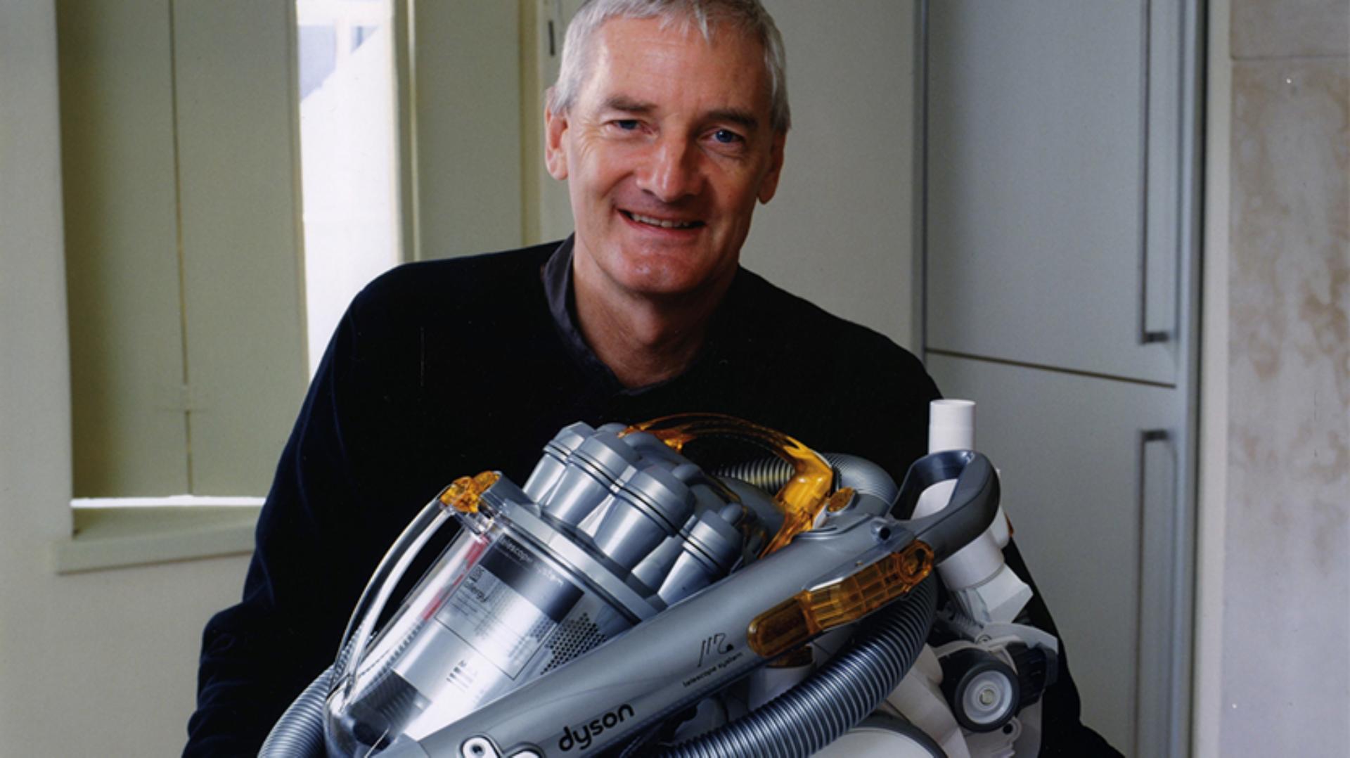 James Dyson sitting with a DC08 vacuum