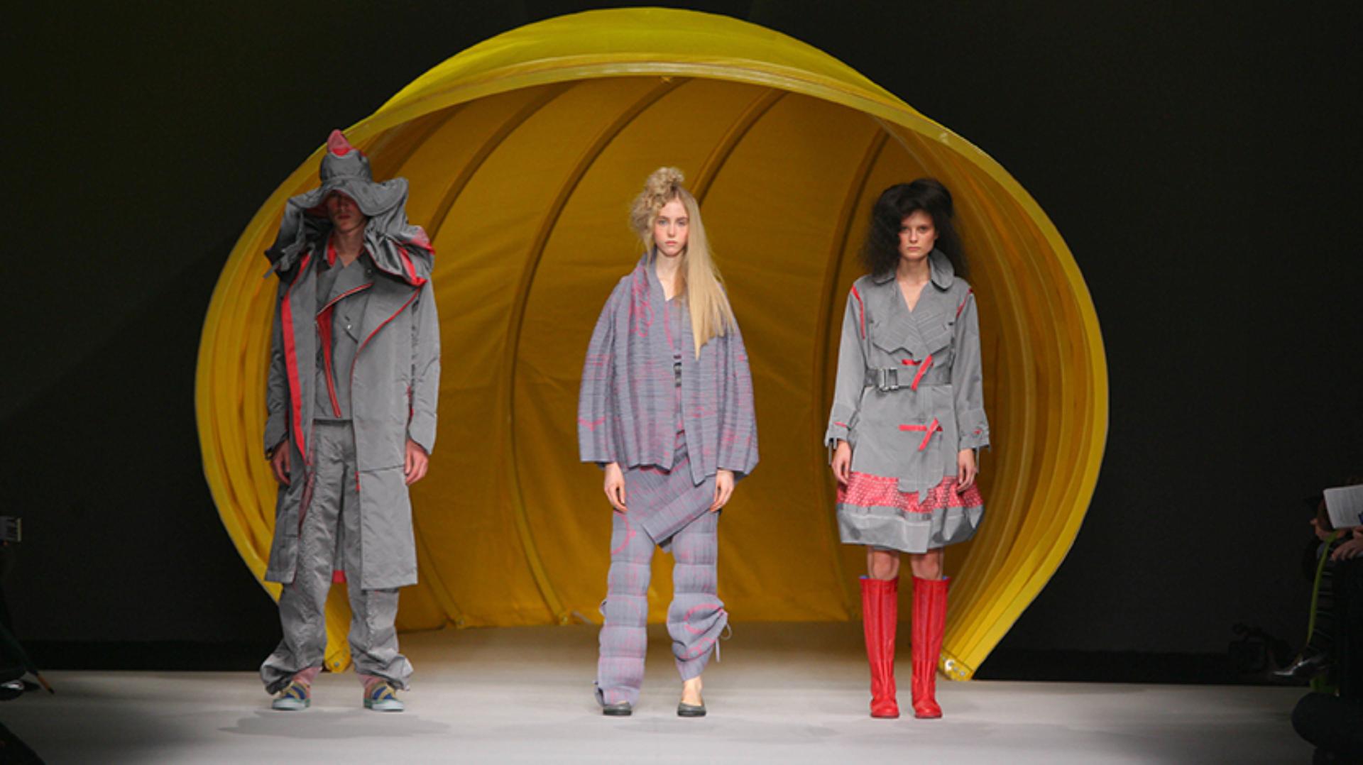 Models emerging from a giant yellow hose in Dyson vacuum-inspired designs onto the runaway