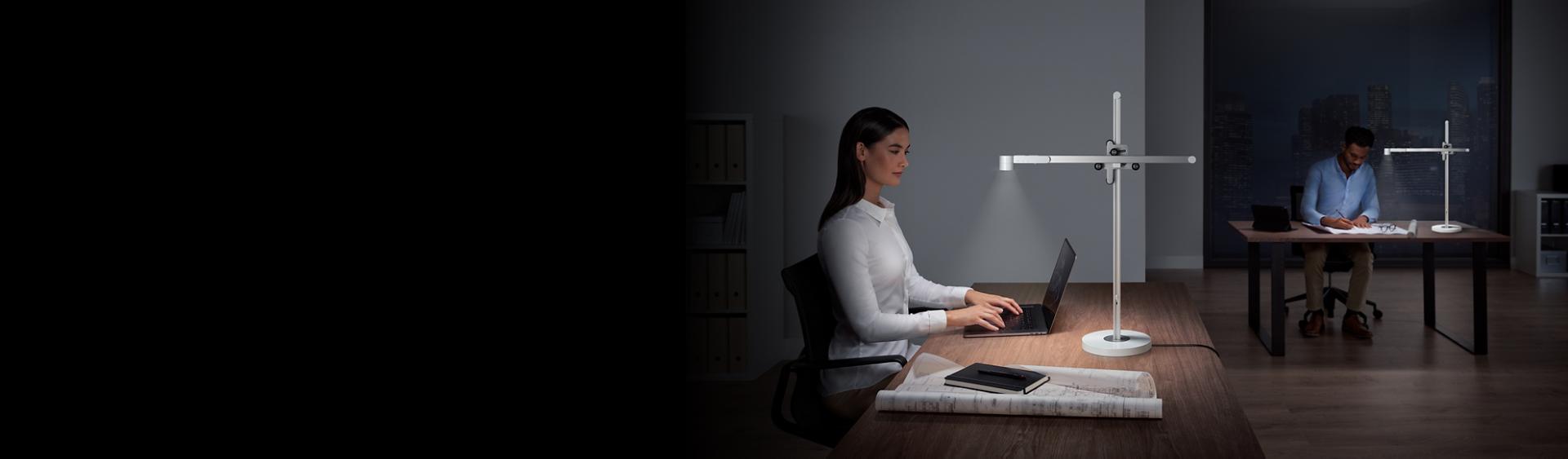 Two people at work using Dyson Lightcycle desk lights