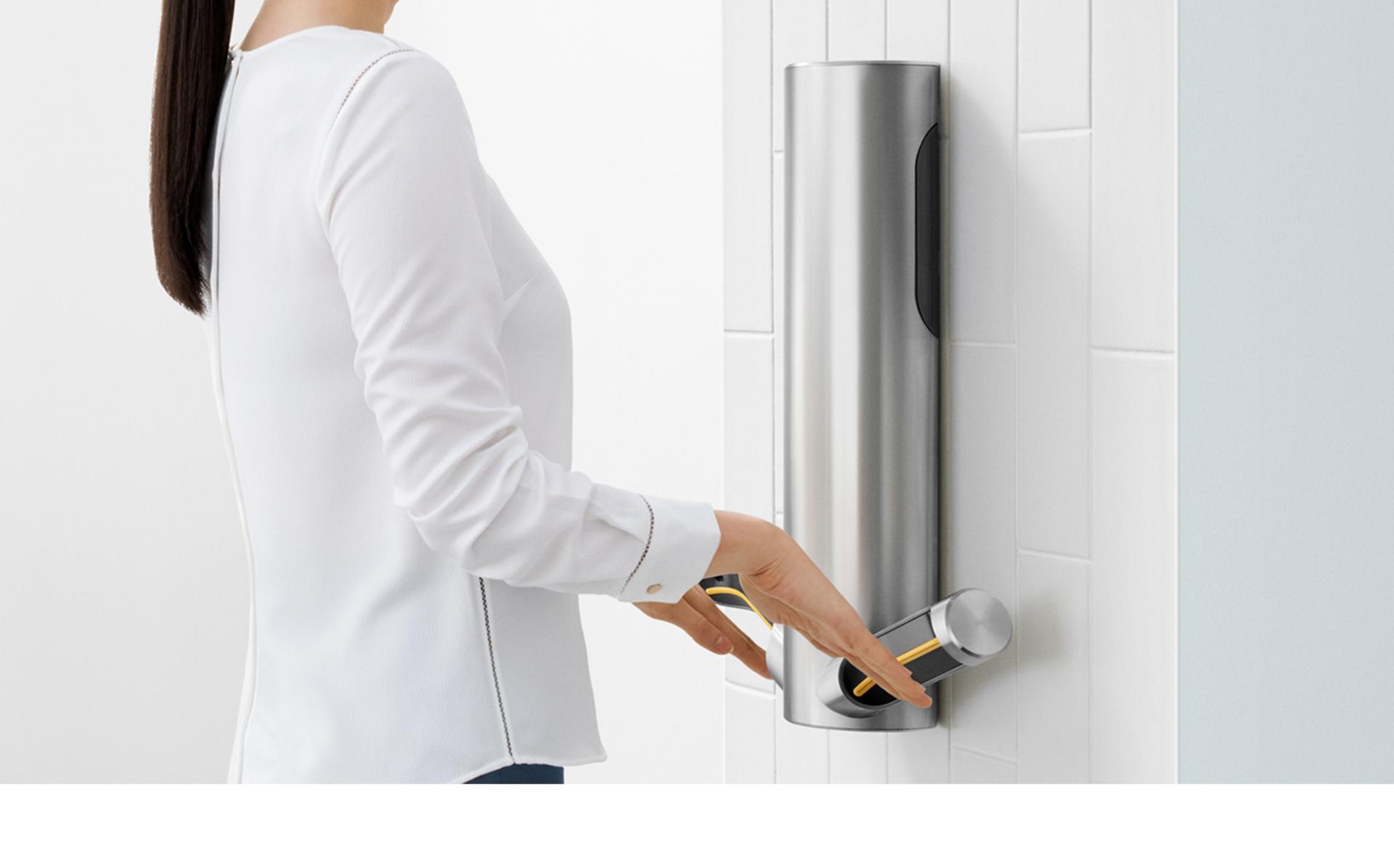 Drying hands underneath Dyson Airblade™ 9kJ hand dryer