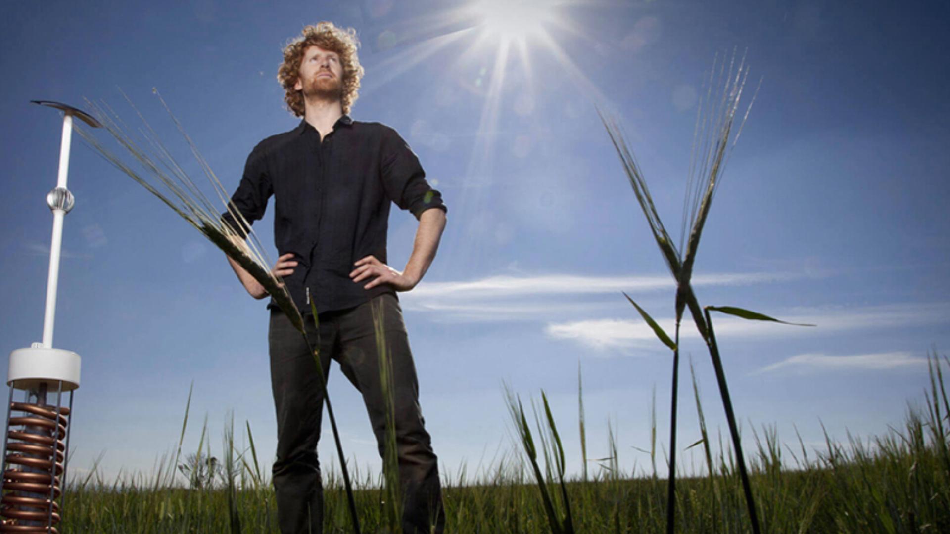 Dyson award winner standing in wheat field beside his invention