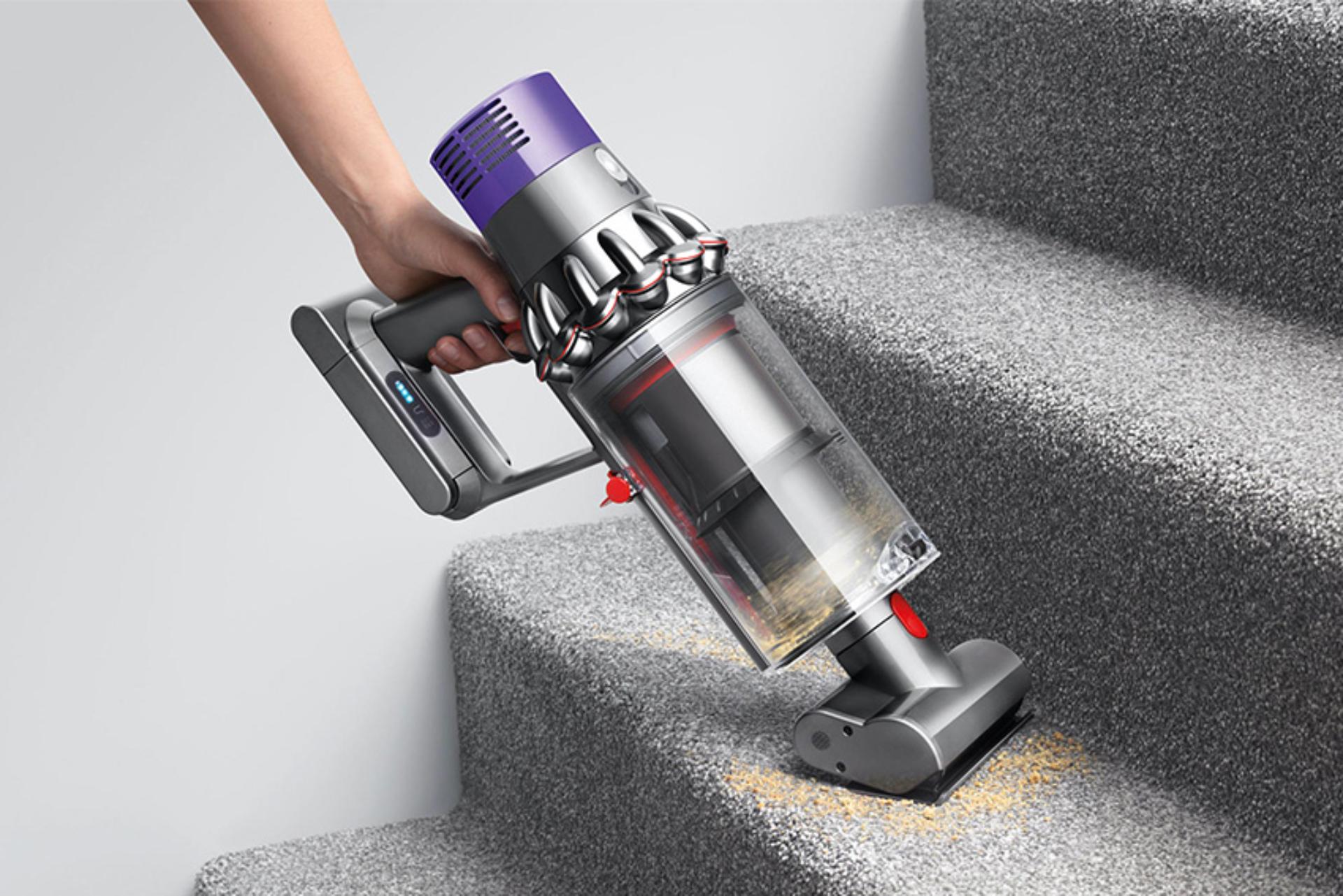 Women using Dyson vacuum on stairs