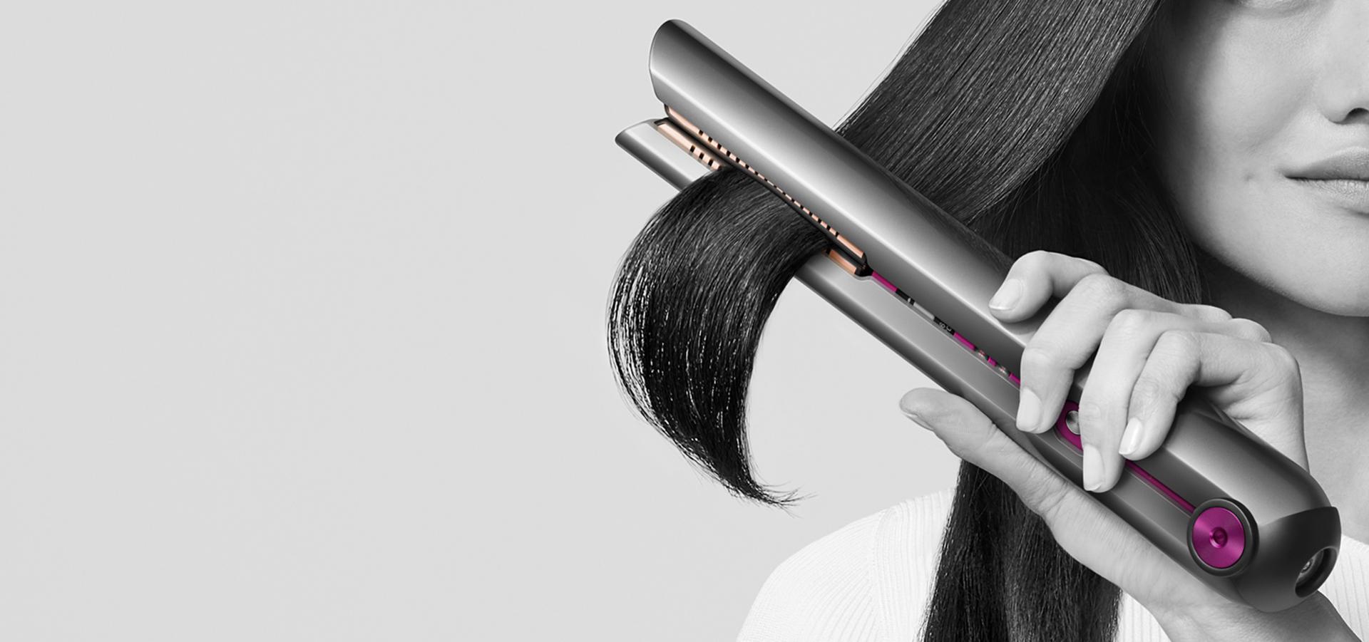 Woman straightening her hair with the Dyson Corrale straightener