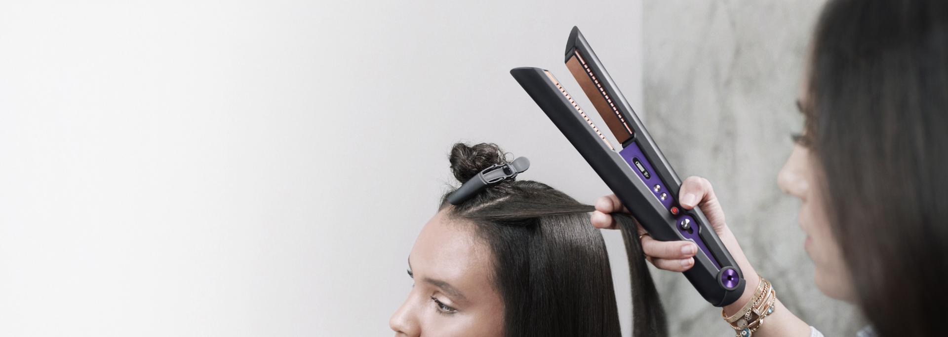 A stylist using the Dyson Corrale™ straightener Professional