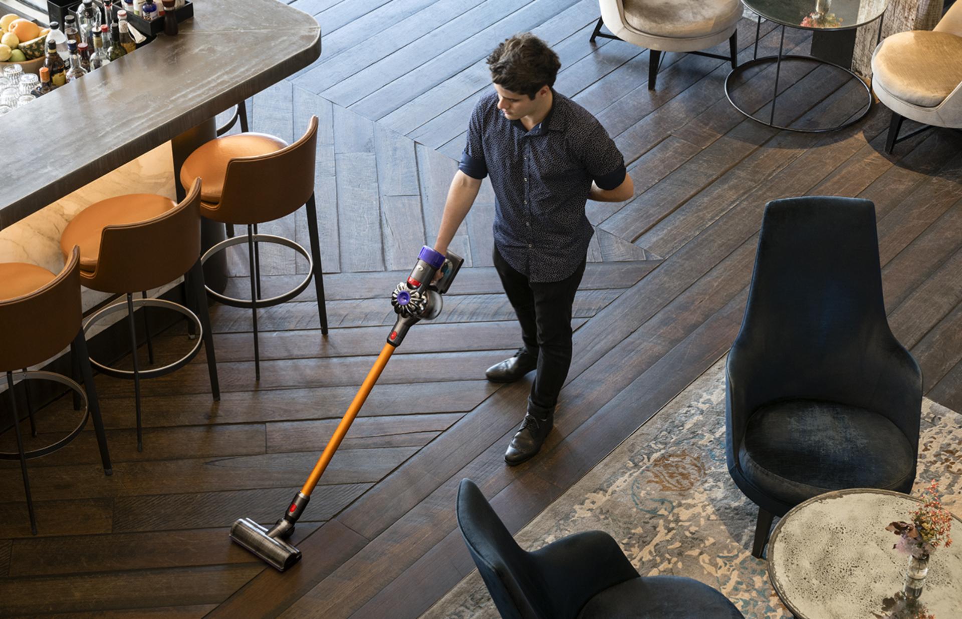 Man using a Dyson vacuum to clean an establishment